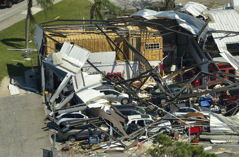 commercial-tornado-damage a damaged car lot after a tornado with debris all over