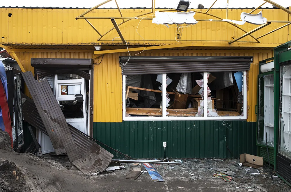 a store with broken windows and debris infront of it after a storm
