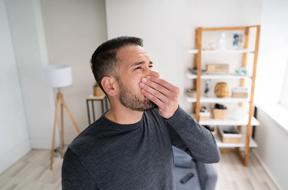 man squeezing his nose