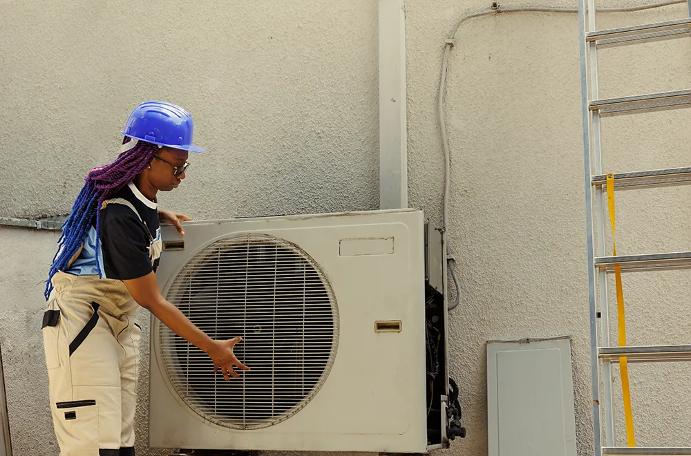 a worker checking an HVAC unit
