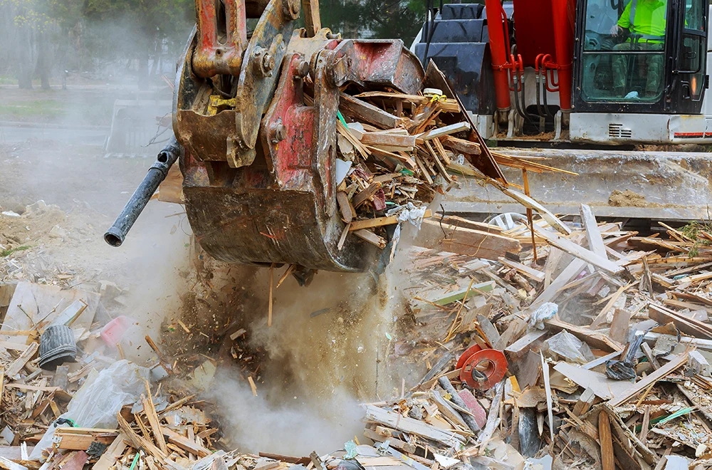 cleaning-debris an excavator picking up debris after a storm